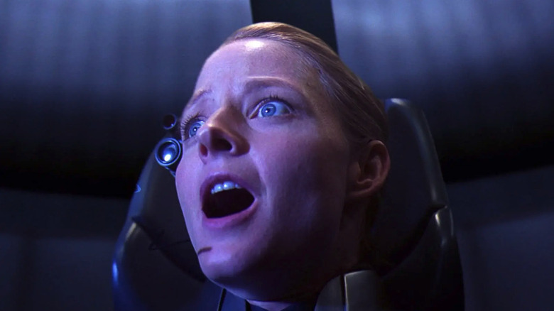 Dr. Arroway (Jodie Foster) shocked by something off-screen as she sits in a space capsule chair in Contact