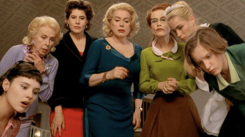 Virginie Ledoyen as Suzon, Danielle Darrieux as Mamy, Fanny Ardant as Pierrette, Catherine Deneuve as Gaby, Isabelle Huppert as Augustine, Emmanuelle Béart as Louise, and Ludivine Sagnier as Catherine all looking down in 8 Women