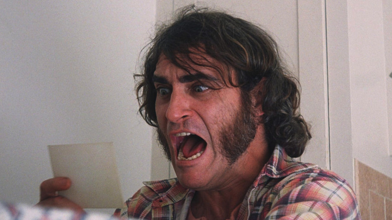 Joaquin Phoenix as Larry "Doc" Sportello screaming at a photo of a baby in Inherent Vice