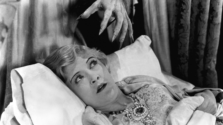 Laura La Plante as Annabelle West in bed with hand behind her in The Cat and the Canary (1927)
