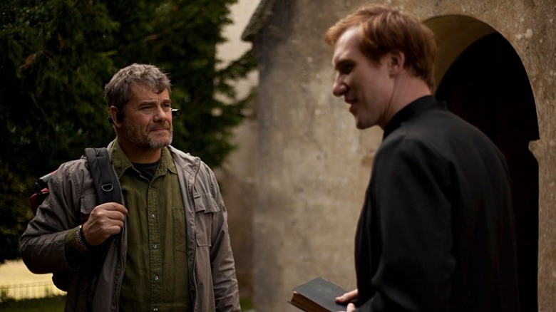 Deacon and Father Crellick (Gordon Kennedy and Luke Neal) confer outside the tiny church in The Borderlands