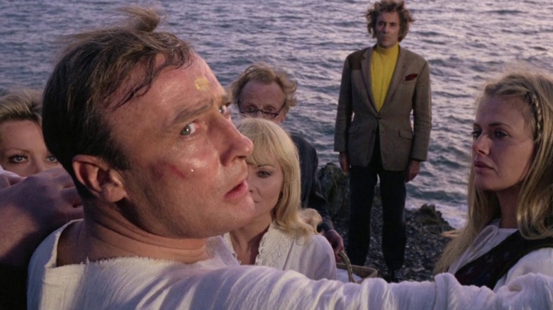 Howie (Edward Woodward) is braced by the islanders while Lee's Lord Summerisle observes in The Wicker Man