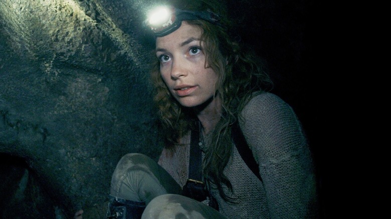 Perdita Weeks as Scarlett Marlowe, crouched in the catacombs in As Above, So Below
