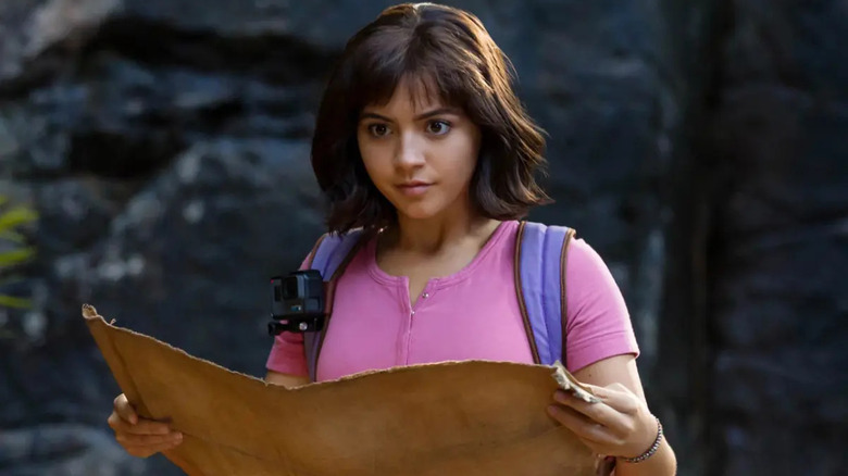 Isabela Merced as Dora, looking down at a map in Dora and the Lost City of Gold