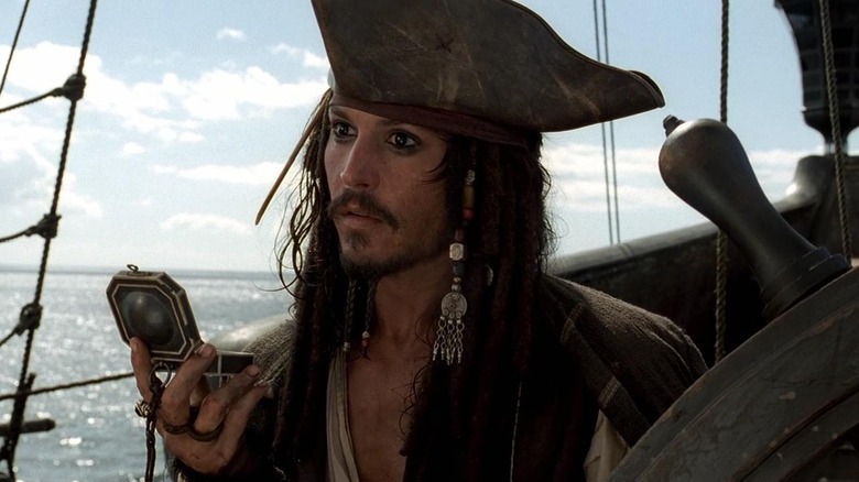 Johnny Depp as Captain Jack Sparrow, sailing and consulting a compass in Pirates of the Caribbean: Curse of the Black Pearl