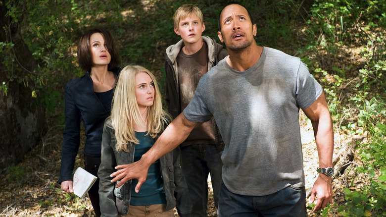 Dwayne Johnson as Jack Bruno holds back AnnaSophia Robb as Sara, Alexander Ludwig as Seth, and Carla Gugino as Dr. Alex in the jungle in Race to Witch Mountain