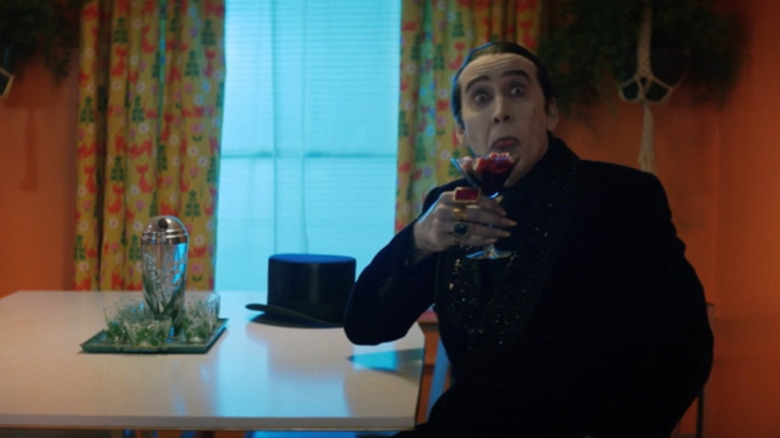 Dracula (Nicolas Cage) makes face while holding martini glass full of eyeballs in Renfield