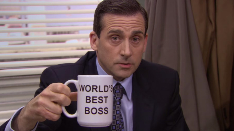 Steve Carell as Michael Scott showing a World's Best Boss mug to the camera in The Office (US)
