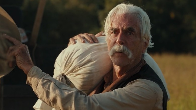 Shea Brennan (Sam Elliott) stares in horror while holding a sack over his shoulder in 1883