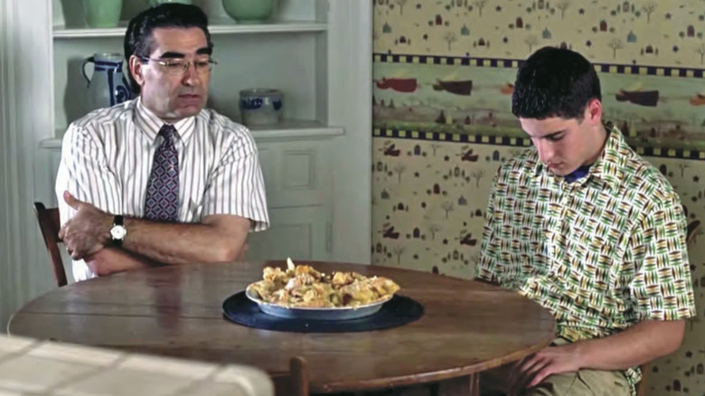 Eugene Levy as Jim's Dad looking curiously at the pie destroyed by Jason Biggs as Jim Levenstein as they sit in the kitchen in American Pie