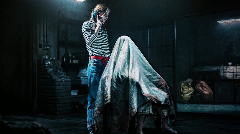 person under sheet while woman calls