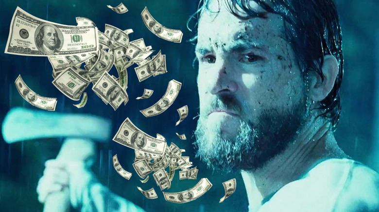 Ryan Reynolds as George Lutz swinging an ax surrounded by money in The Amityville Horror (2005)