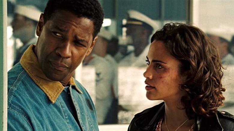 Denzel Washington as Doug Carlin looks around a corner while Paula Patton as Claire Kuchever looks at him in Déjà Vu
