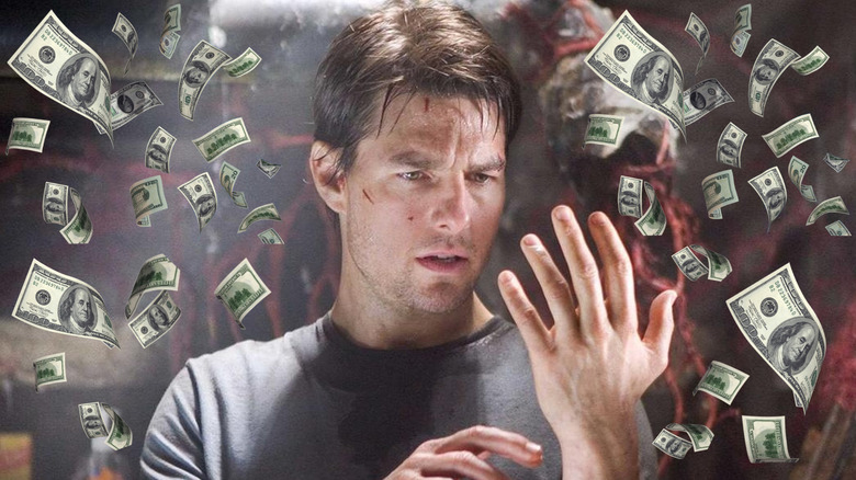 Tom Cruise as Ray looking at his hand surrounded by money in War of the Worlds (2005)