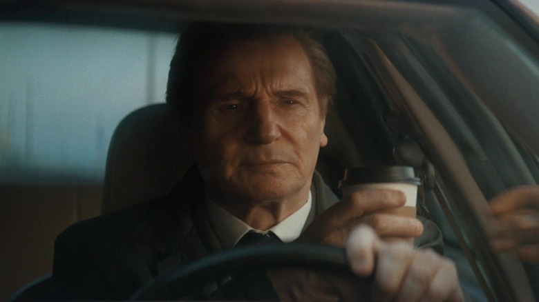 Frank Drebin Jr. accepting a cup of coffee while driving in The Naked Gun (2025)