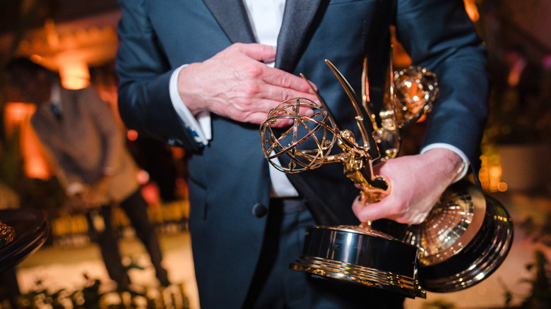 Noah Wyle's hands holding two Emmy Awards
