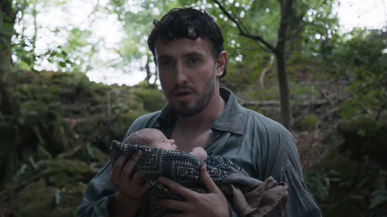 Paul Mescal as William Shakespeare, holding a baby in Hamnet