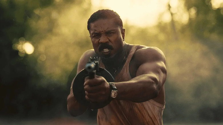 Michael B. Jordan as Smoke Moore, aiming a tommy gun in Sinners