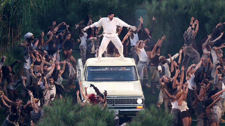 సూపర్ బౌల్ LX సమయంలో కారు పైన ప్రదర్శన చేస్తున్న చెడ్డ బన్నీ