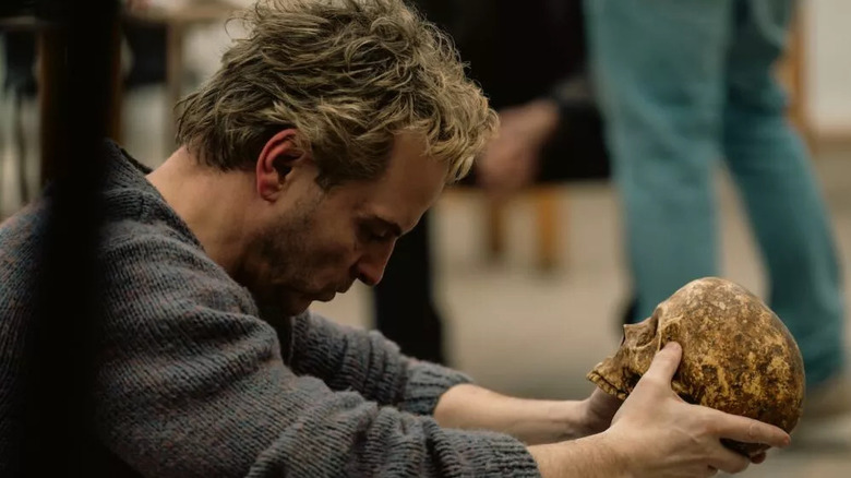 Ian holding a skull and staring at it in Elsinore