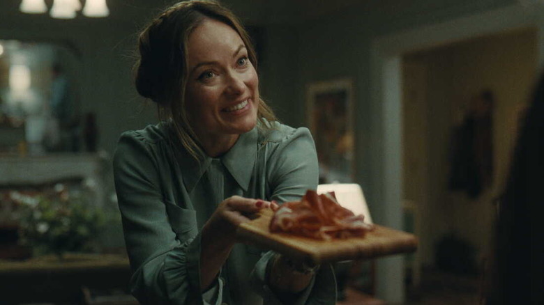 Angela frantically offering a plate of jamon in The Invite