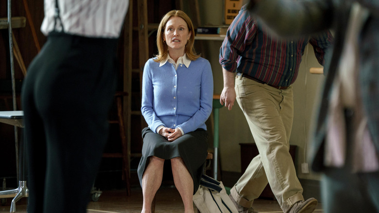 Mona sitting amidst a crowd in a classroom looking stressed in The Debut