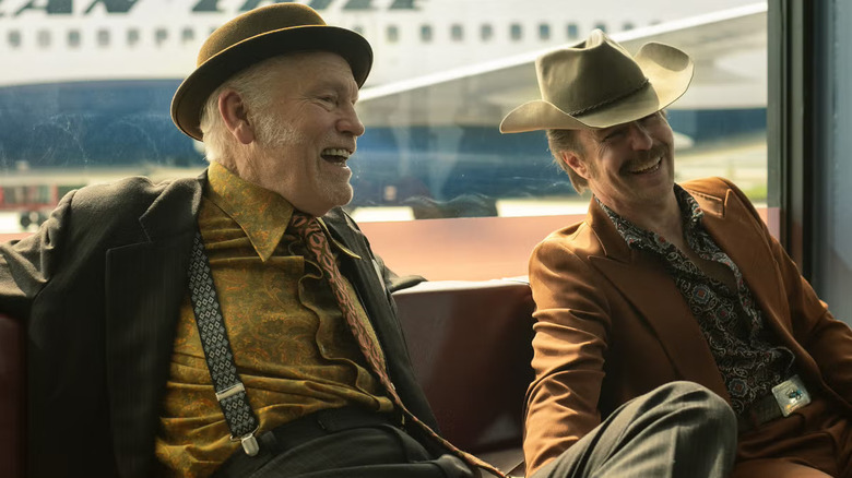 Chris and Lee laughing together in an airport in Wild Horse Nine