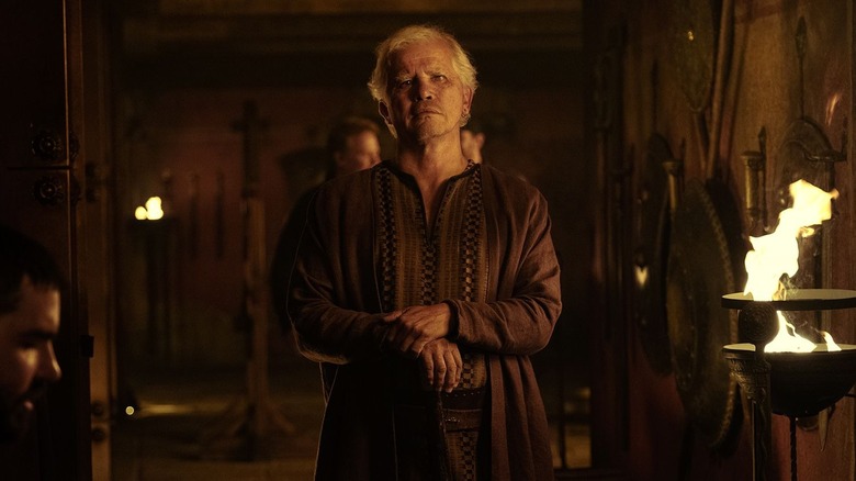 Eumaeus standing in the hall with his arms crossed in The Odyssey