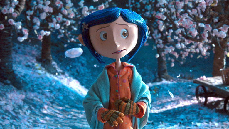Coraline Jones (Dakota Fanning) stands under budding cherry trees in Coraline