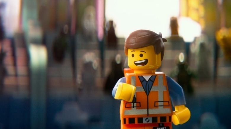 Emmet Brickowski (Chris Pratt) walks triumphantly smiling in The LEGO Movie