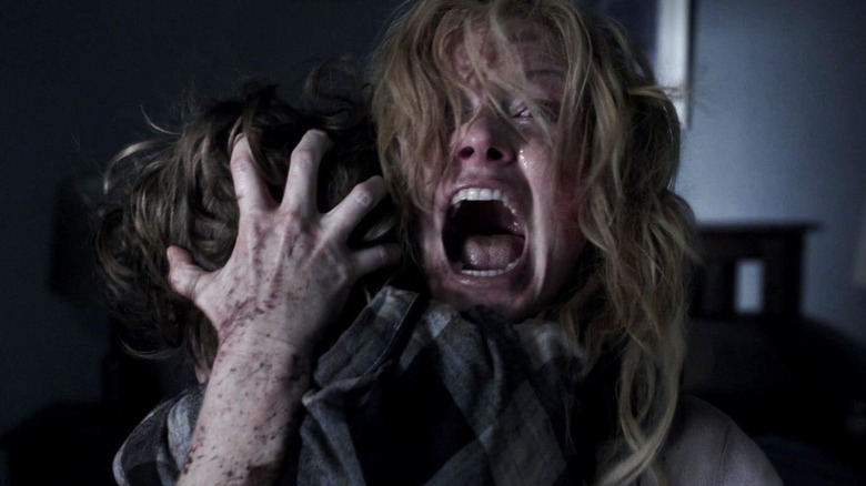 Essie Davis' Amelia Vanek screaming while holding her son in The Babadook