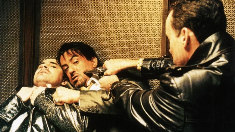 John C. McGinley as Con McCarty holding a gun to the head of Sylvester Stallone as Jack Carter as he chokes Yves Cameron as Peter in Get Carter (2000)
