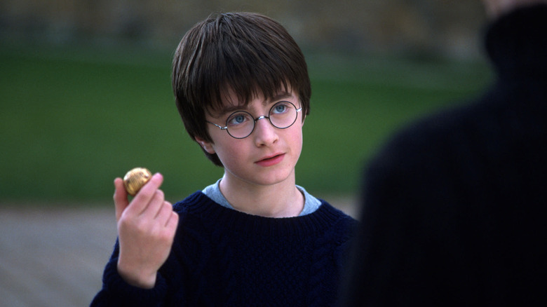 Harry brandissant le vif d'or dans Harry Potter à l'école des sorciers