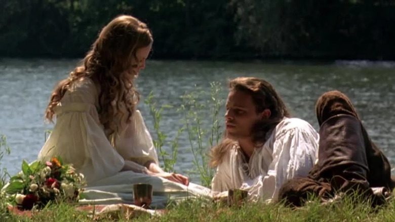 Francesca Bonacieux and d'Artagnan lying next to a stream in The Musketeer