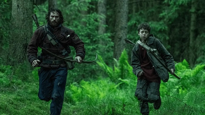 Jamie and Spike running through a forest in 28 Years Later