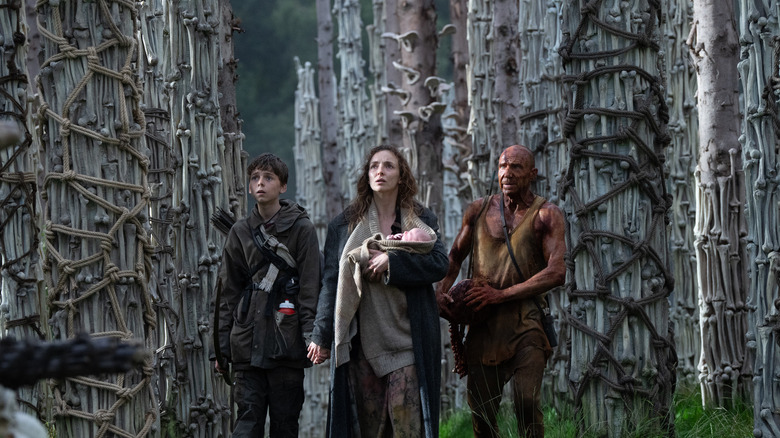 Spike, Isla (keeps baby) and Dr. Ian Kelson, who stands among many bones 28 years later