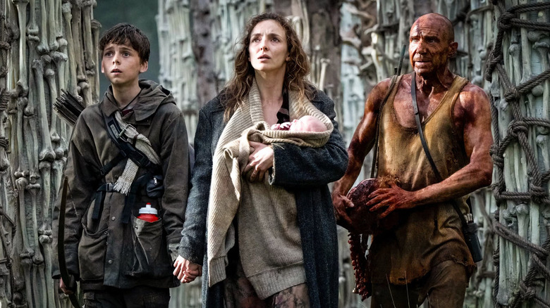 28 Years Later, Spike, Dr. Kelson, and Isla holding a baby in the Bone Temple