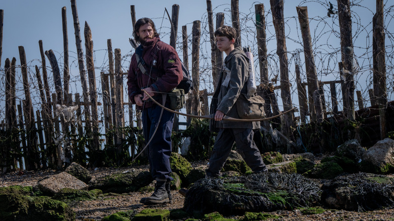 Jamie and Spike walking past a barbed wire fence
