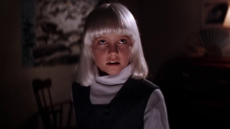 Lindsey Haun as Mara looking up with evil eyes in her room in Village of the Damned (1995)