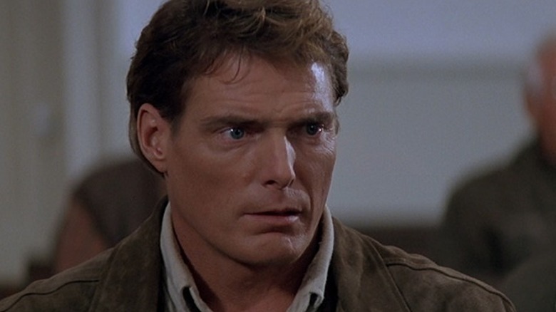 Christopher Reeve as Dr. Alan Chaffee sitting with a look of horror on his face in Village of the Damned (1995)
