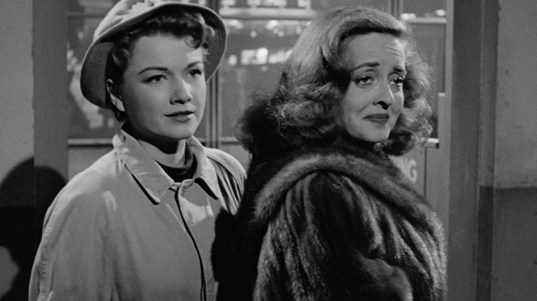 Eve Harrington and Margo Channing, about to exit a theater in All About Eve