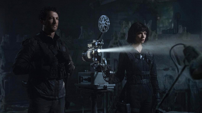 Miles Teller as Levi and Anya Taylor-Joy as Drasa watching a projector in The Gorge