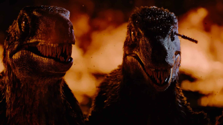 Raptors standing in front of fire at the end of Primitive War