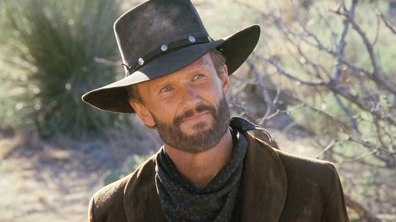 Kris Kristofferson's RIngo Kid smiles as he stands in the desert in Stagecoach