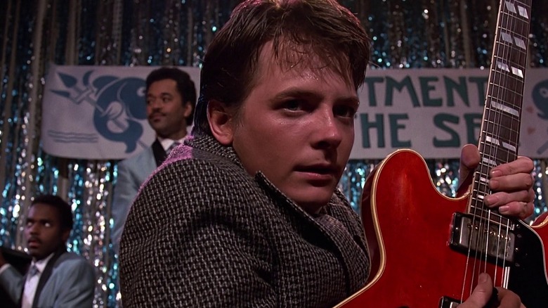 Marty McFly playing his guitar on stage at the dance in Back to the Future