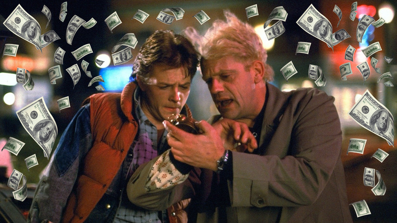 Marty McFly and Doc Brown looking at his watch surrounded by money in Back to the Future