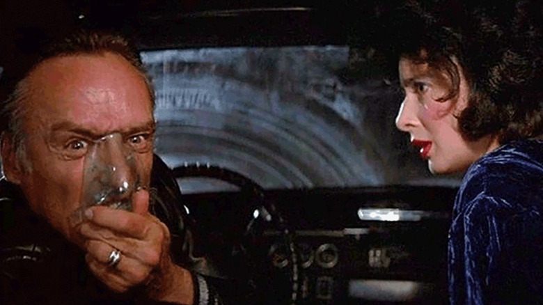 Dorothy Vallens looks on in horror as Frank Booth huffs his gas in Blue Velvet
