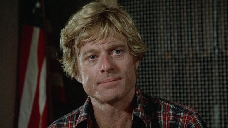 Robert Redford as Henry Brubaker in front of an American Flag in the corner in Brubaker