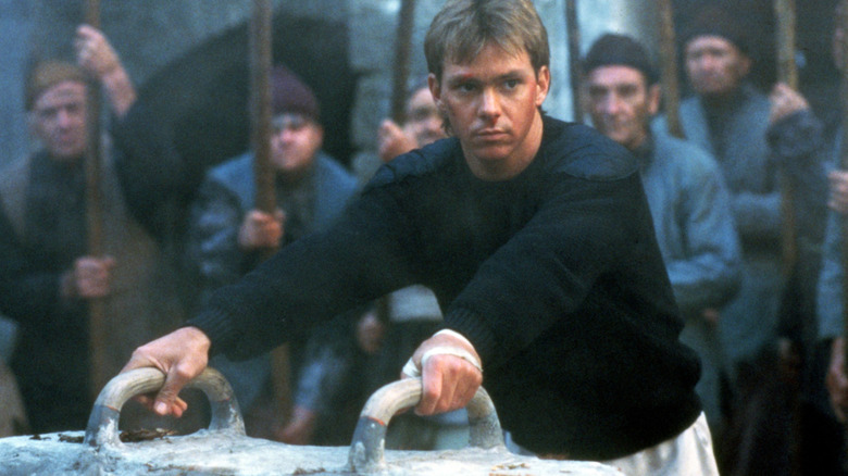 Jonathan Cabit about to get on a stone pommel horse, surrounded by crazed villagers in Gymkats