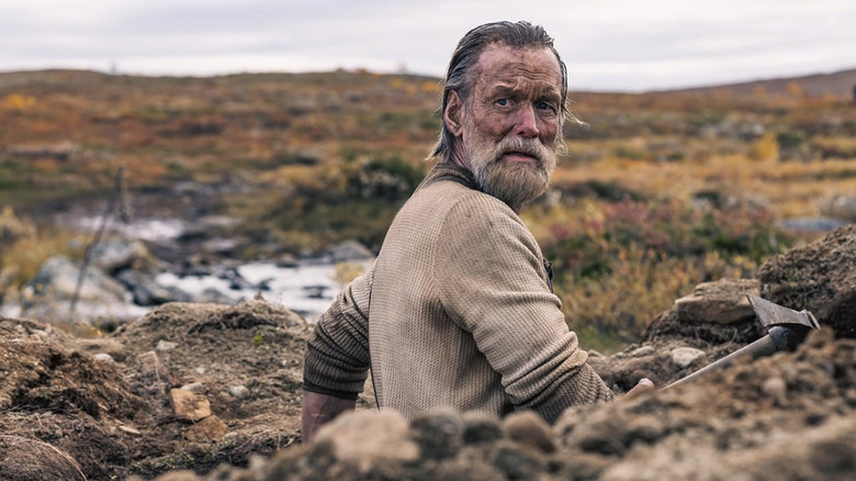 Jorma Tommila as Aatami looking over his shoulder toward something off camera in Sisu